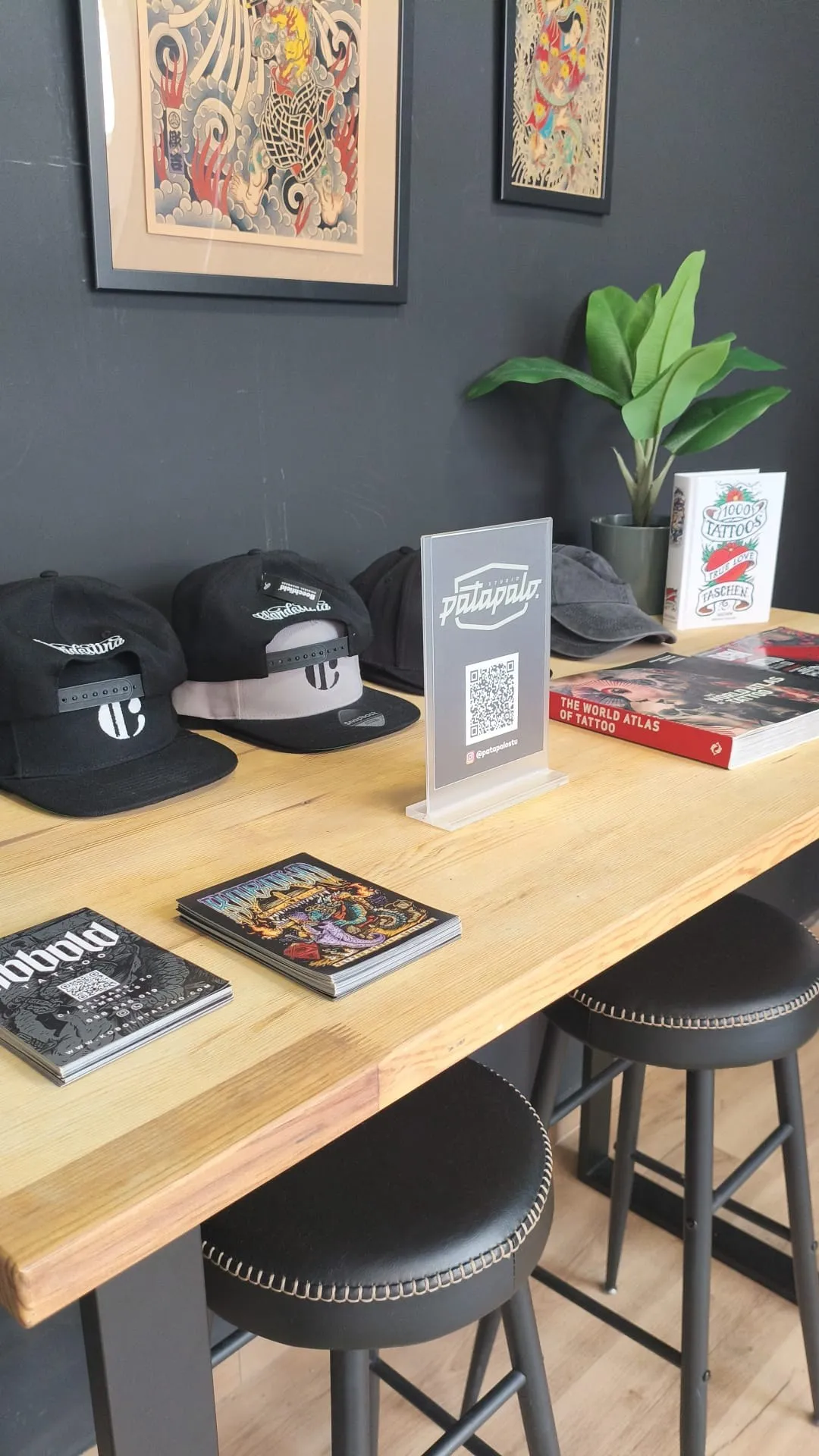 Recepción de Kobold Tattoo con gorras y libros de tatuaje