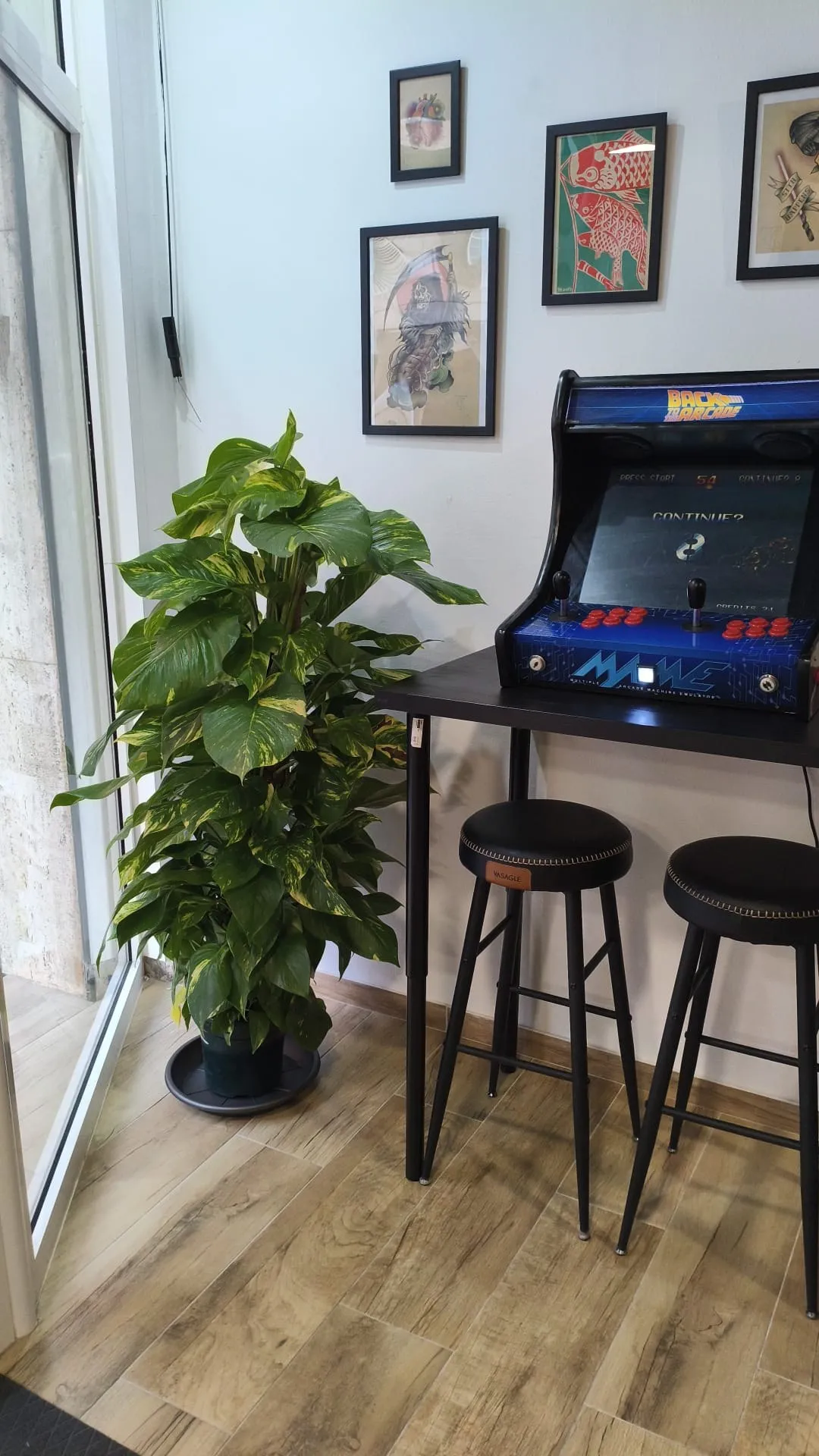 Rincón con máquina arcade en el estudio Kobold Tattoo