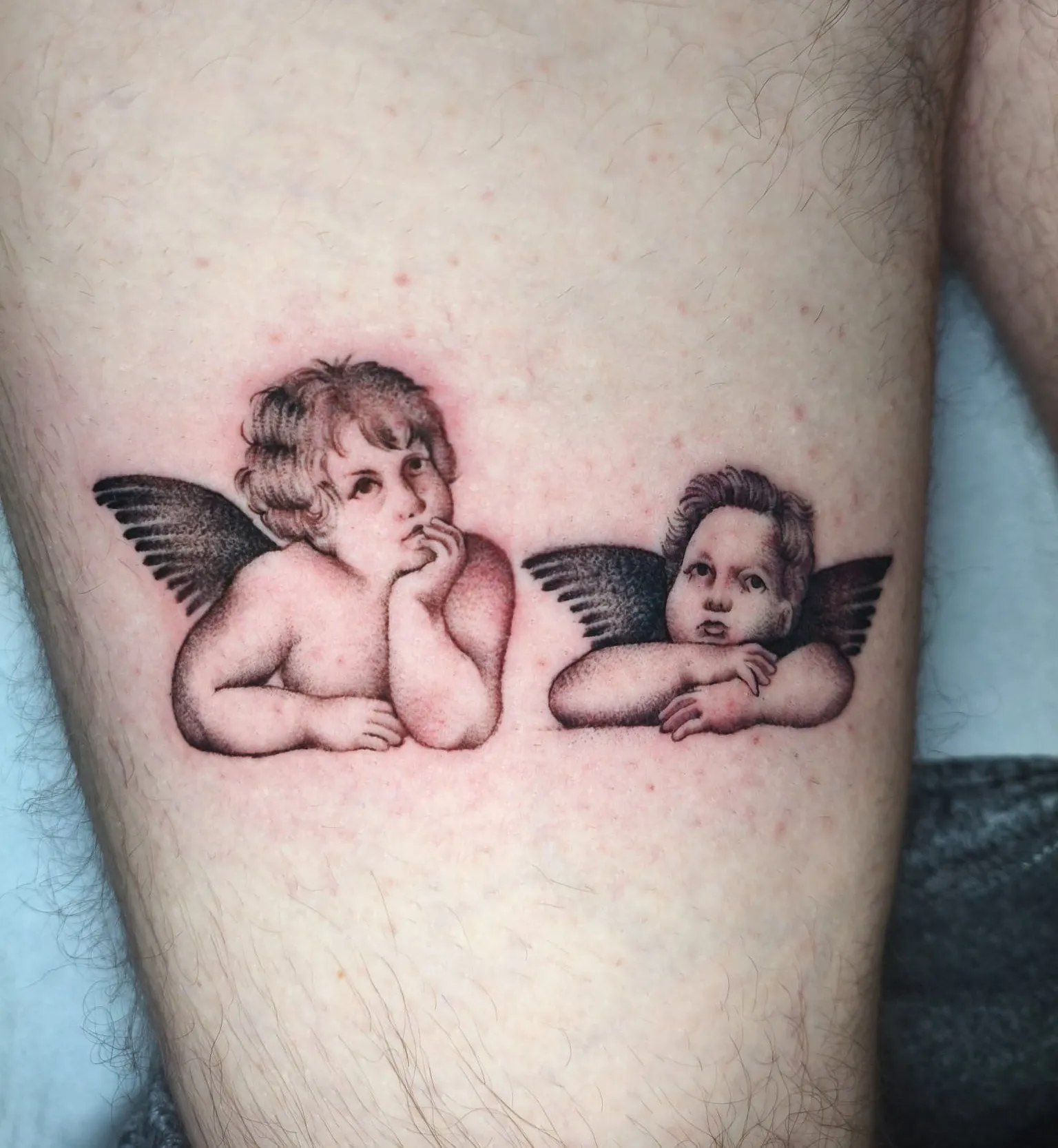 Tatuaje dotwork de los angelitos de Rafael en la pierna
