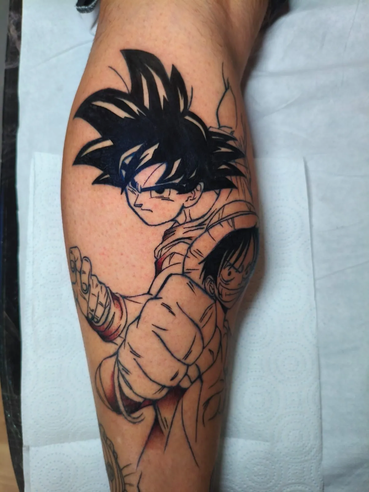 Tatuaje anime lineart de Goku y Luffy en la pierna