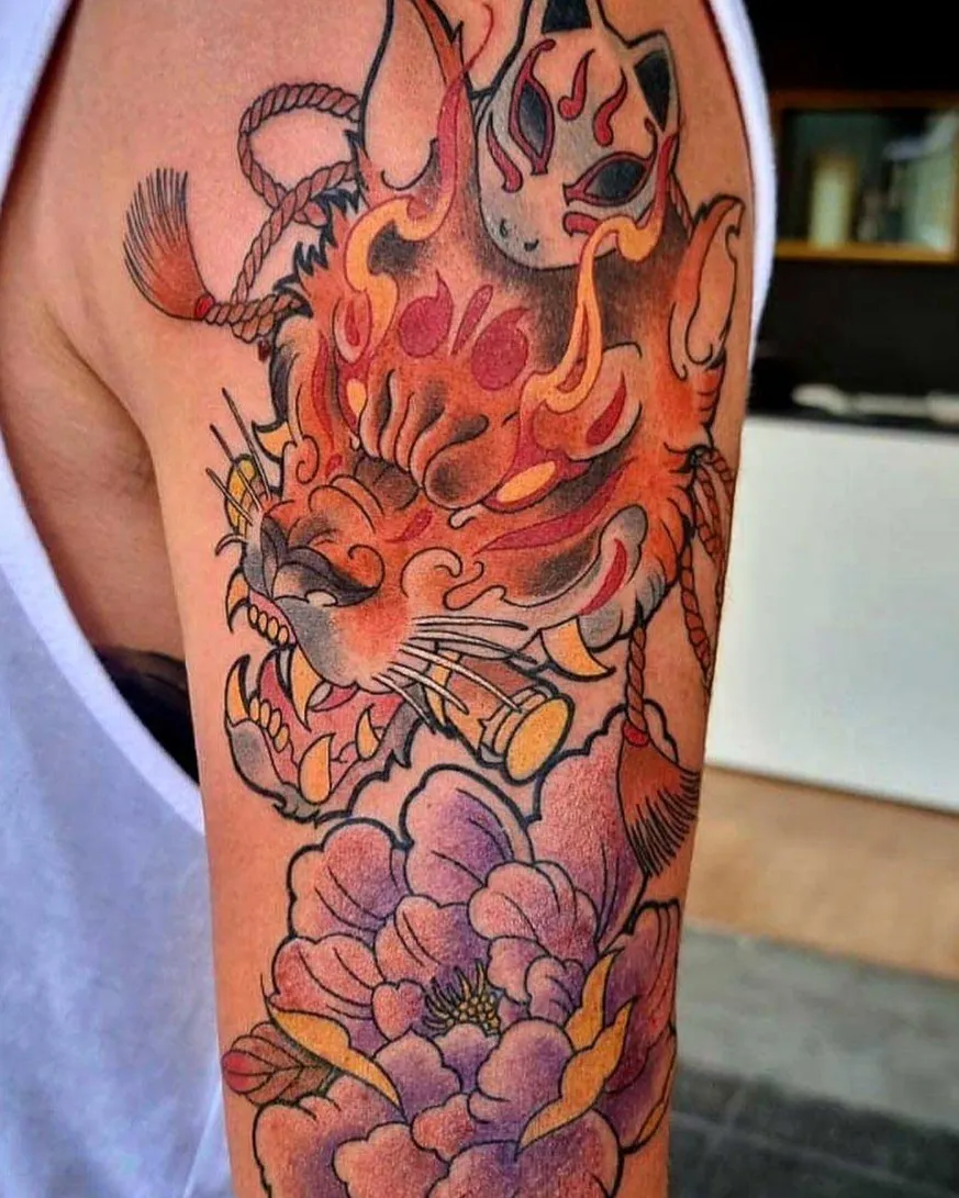 Tatuaje neojaponés de kitsune en llamas con peonías en el hombro