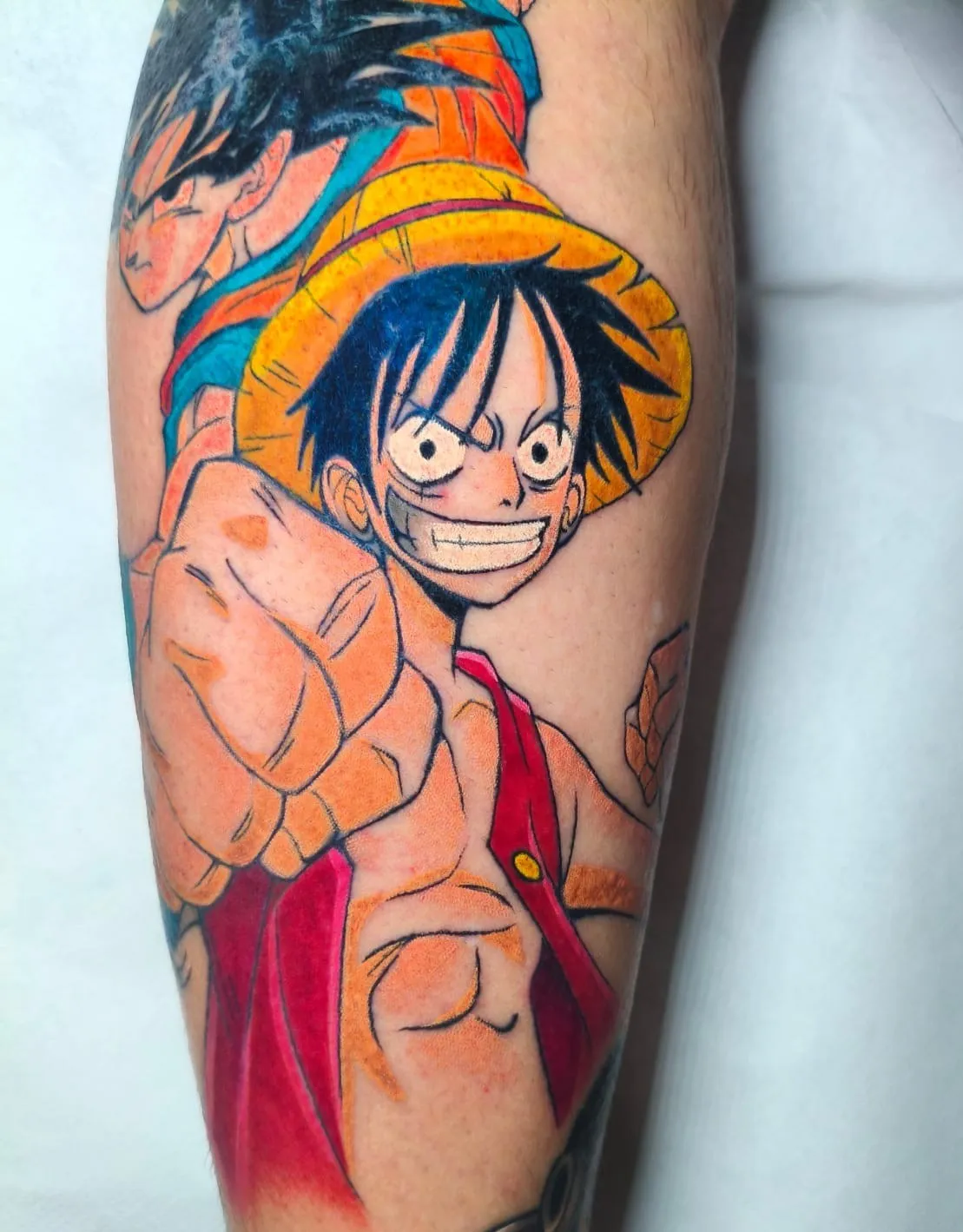 Tatuaje anime a color de Luffy y Goku en la pierna