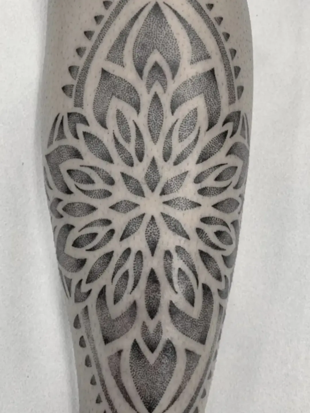 Tatuaje dotwork de mandala ornamental en el gemelo