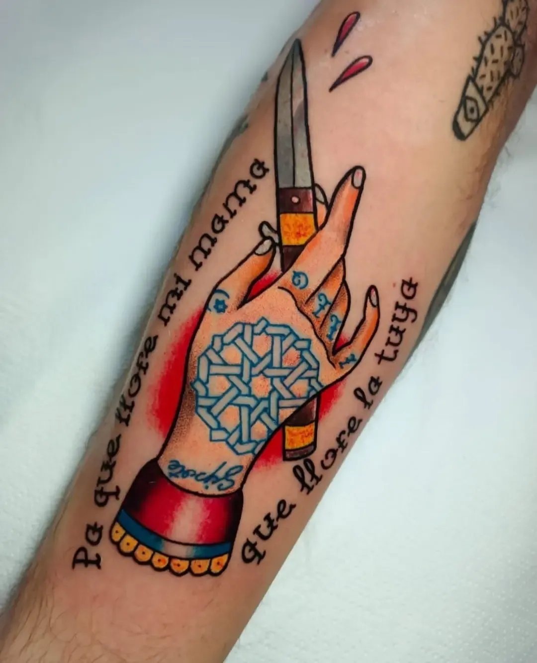 Tatuaje tradicional de mano con navaja y lettering en el antebrazo