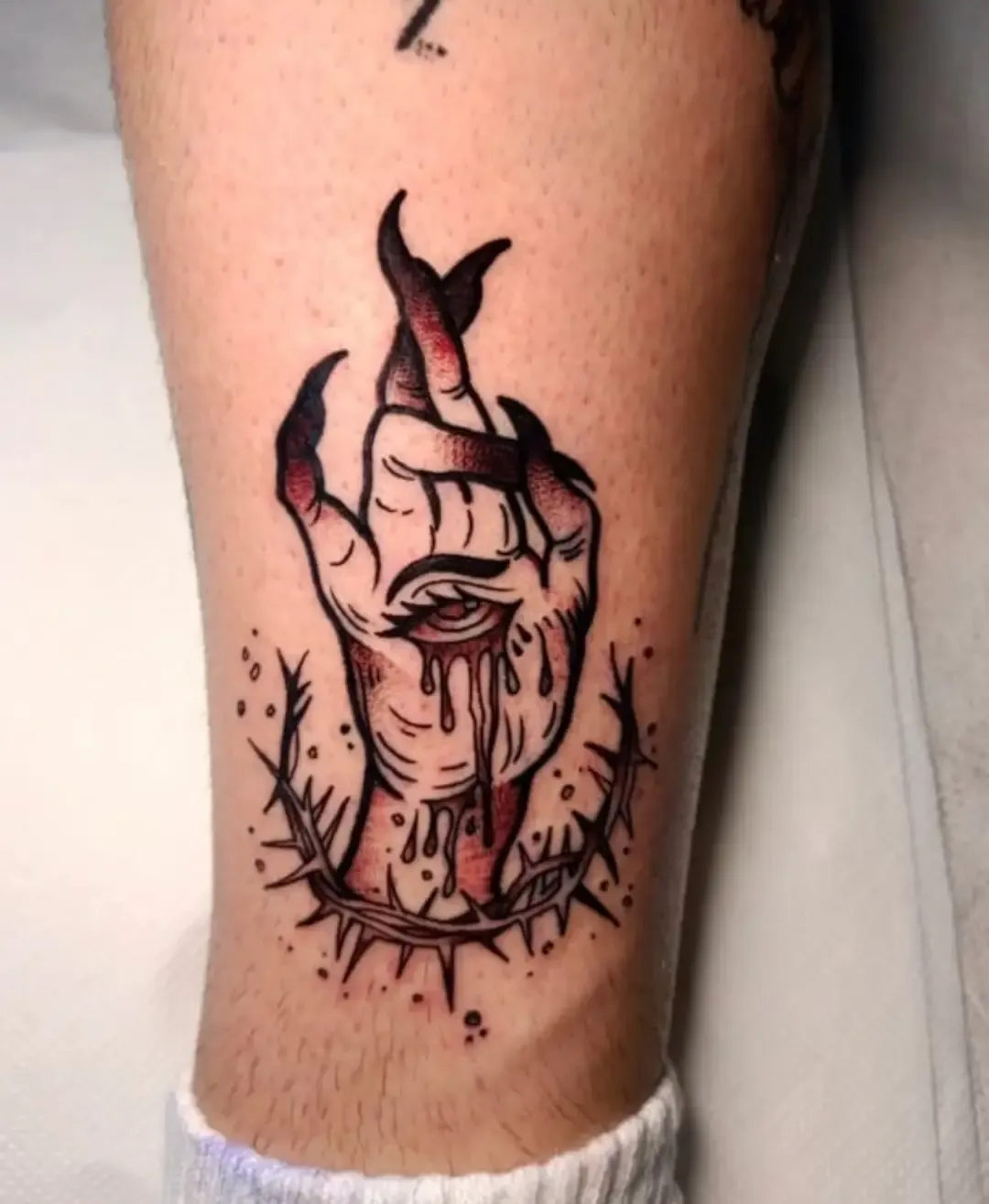 Tatuaje tradicional de mano demoníaca con ojo y corona de espinas