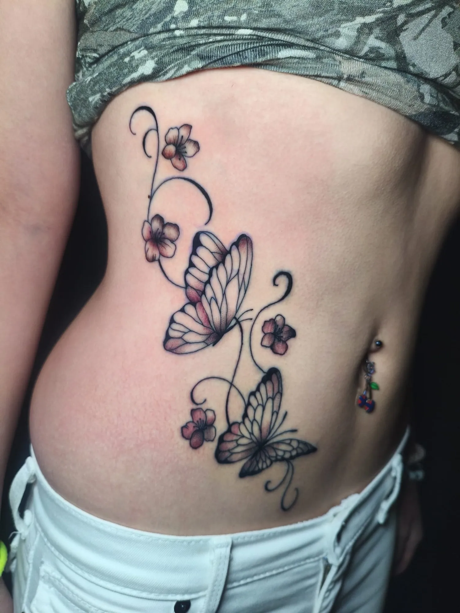 Tatuaje de mariposas con flores en el costado