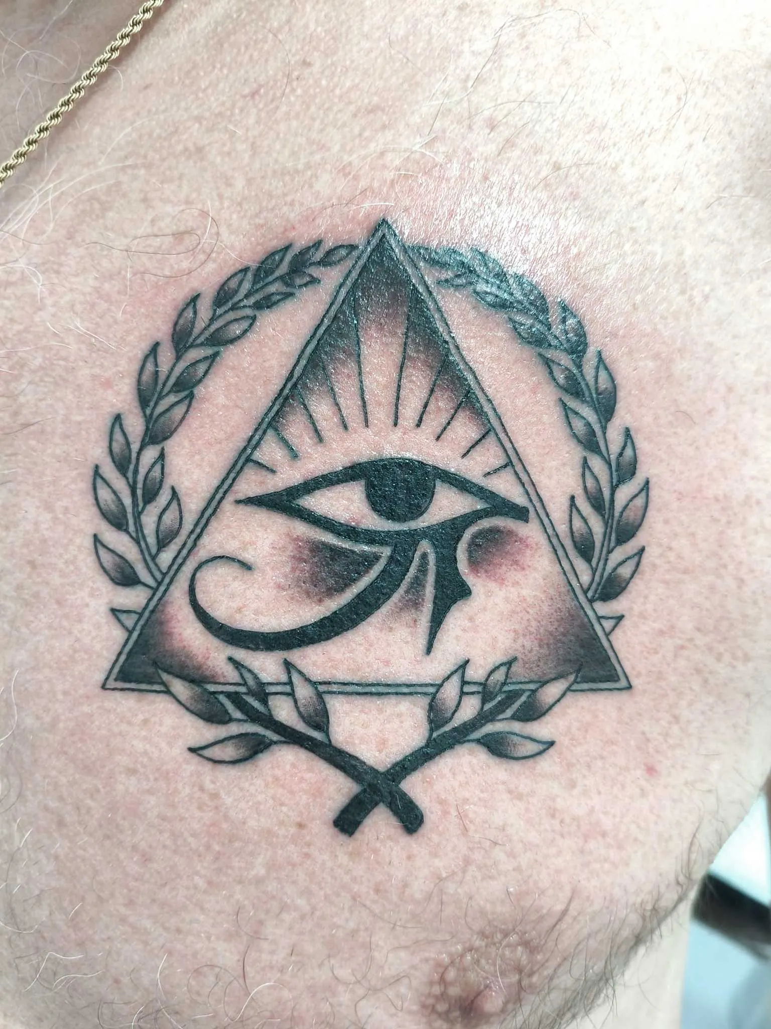Tatuaje black & grey de ojo con corona de laurel