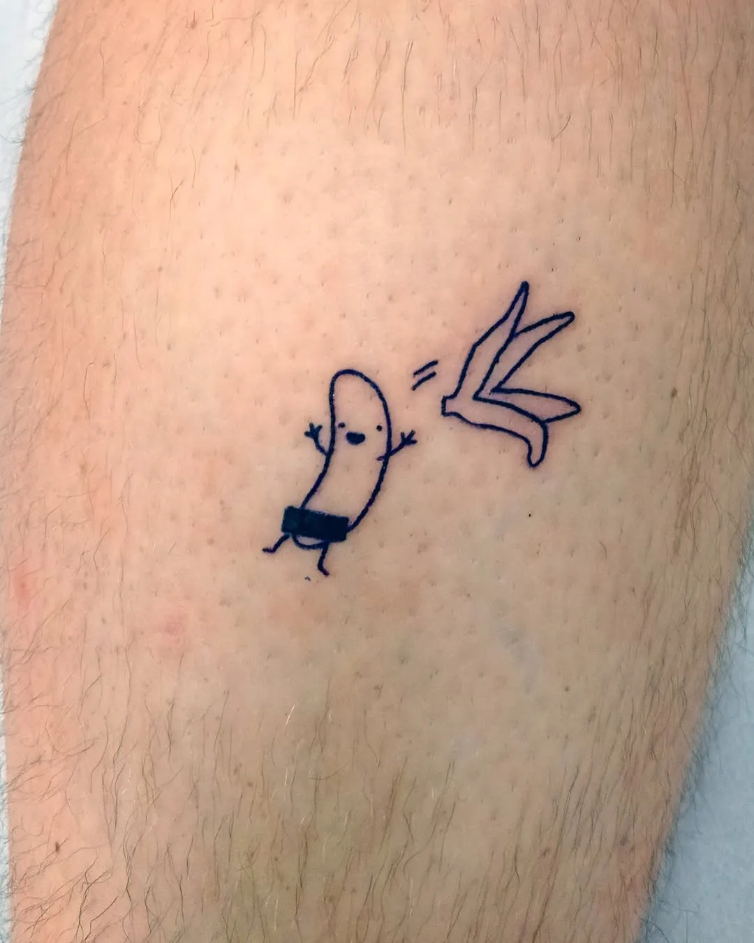 Tatuaje lineart minimalista y humorístico de un plátano saliéndose de su piel