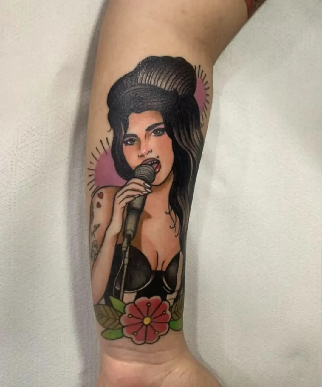 Tatuaje neotradicional retrato de Amy Winehouse en el antebrazo