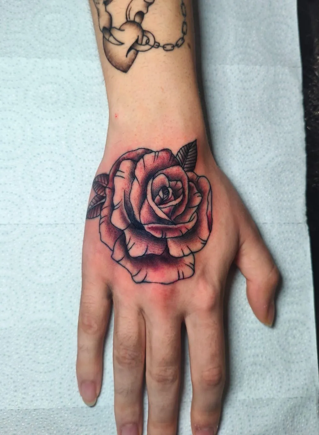Tatuaje black & grey de rosa en la mano