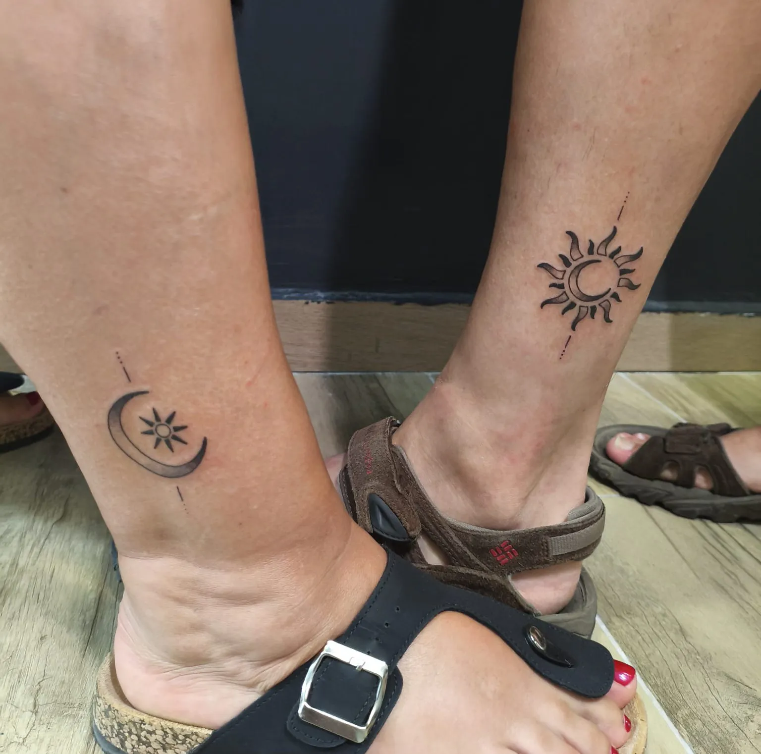 Tatuajes a juego de sol y luna en los tobillos de una pareja