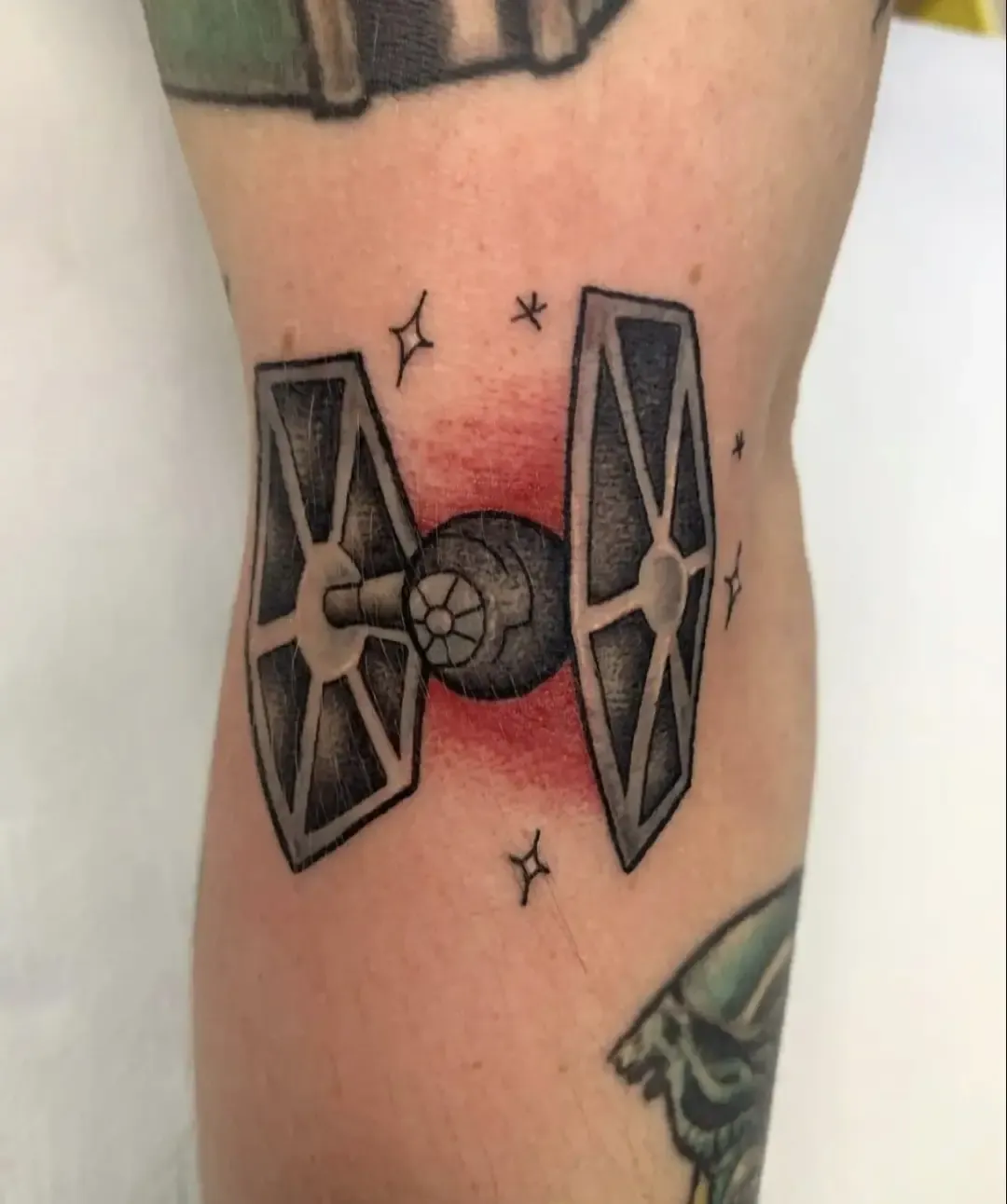 Tatuaje tradicional de caza TIE de Star Wars en el brazo