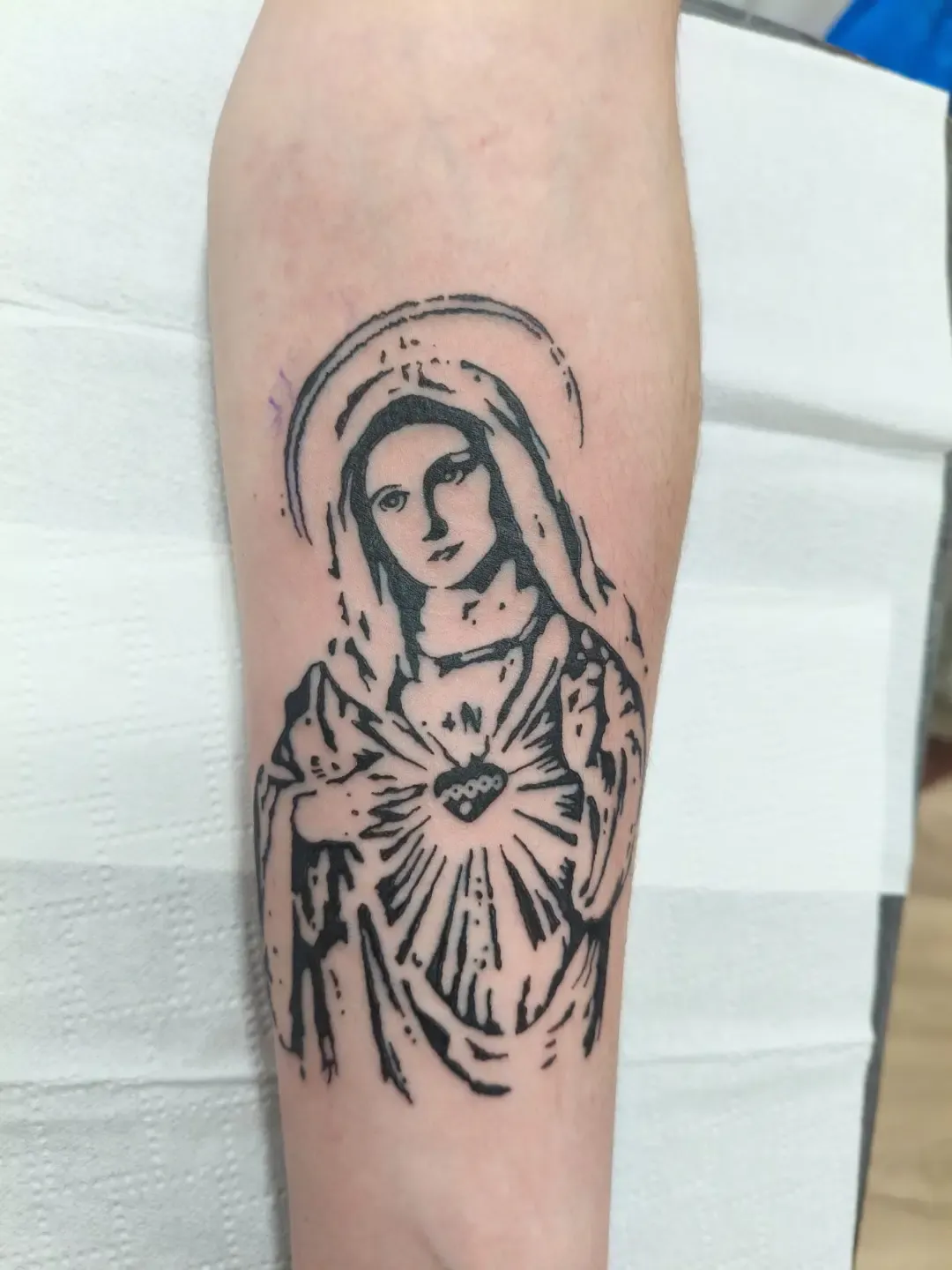 Tatuaje blackwork de la Virgen María con sagrado corazón en el antebrazo
